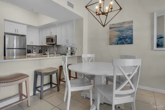 a dining room with a table chairs and a kitchen view