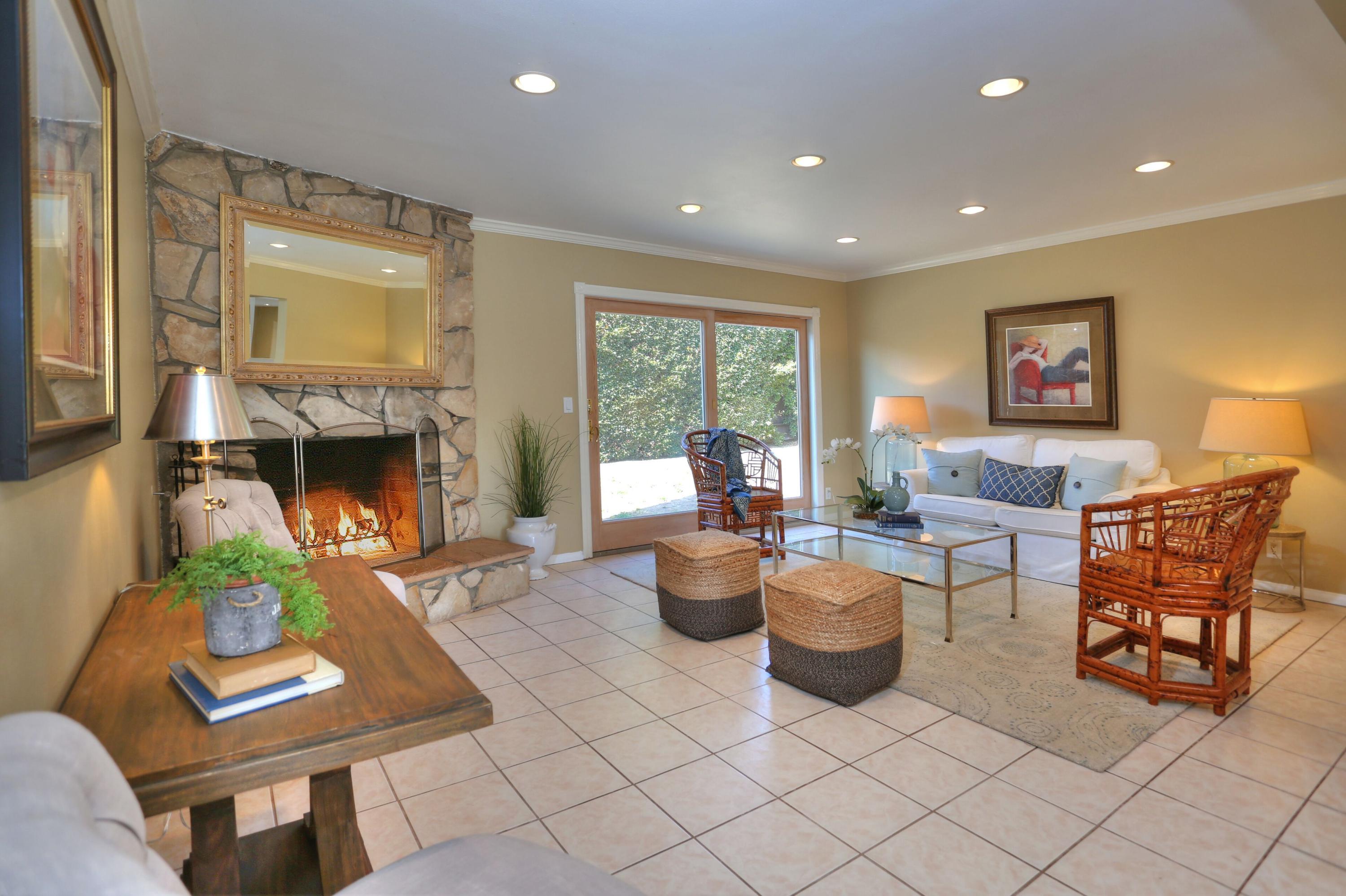 5668 Encina Road Goleta, CA 93117 - Photo 2 of 16 a living room with furniture a fireplace and a table