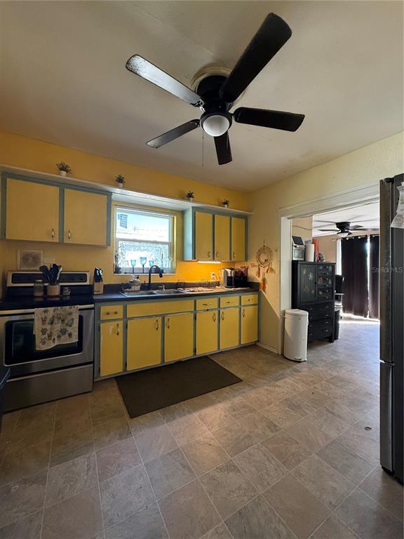 6100 Main Street, Unit A New Port Richey, FL 34653 - Photo 5 of 23 a kitchen with stainless steel appliances kitchen island granite countertop a refrigerator and a stove top oven