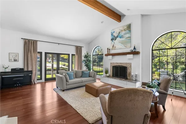 a living room with furniture fireplace and a large window
