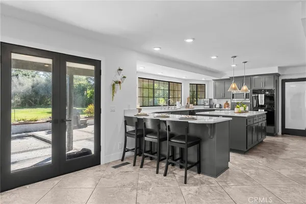 a kitchen with a sink a stove and chairs