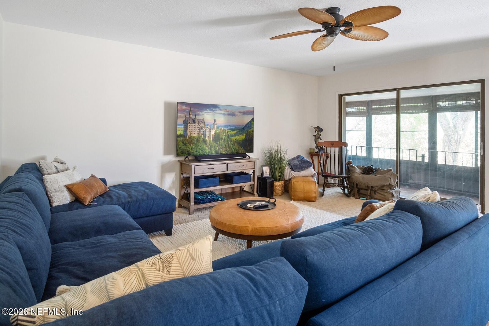 8012 Hollyridge Road, Unit 17U Jacksonville, FL 32256 - Photo 8 of 22 a living room with furniture a flat screen tv and a window
