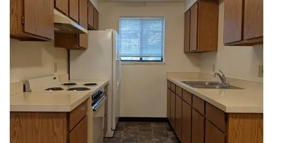 a kitchen with a sink stove top oven and cabinets