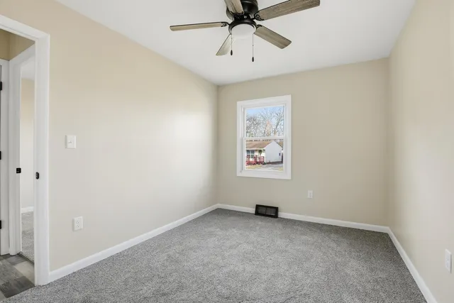 an empty room with chandelier fan