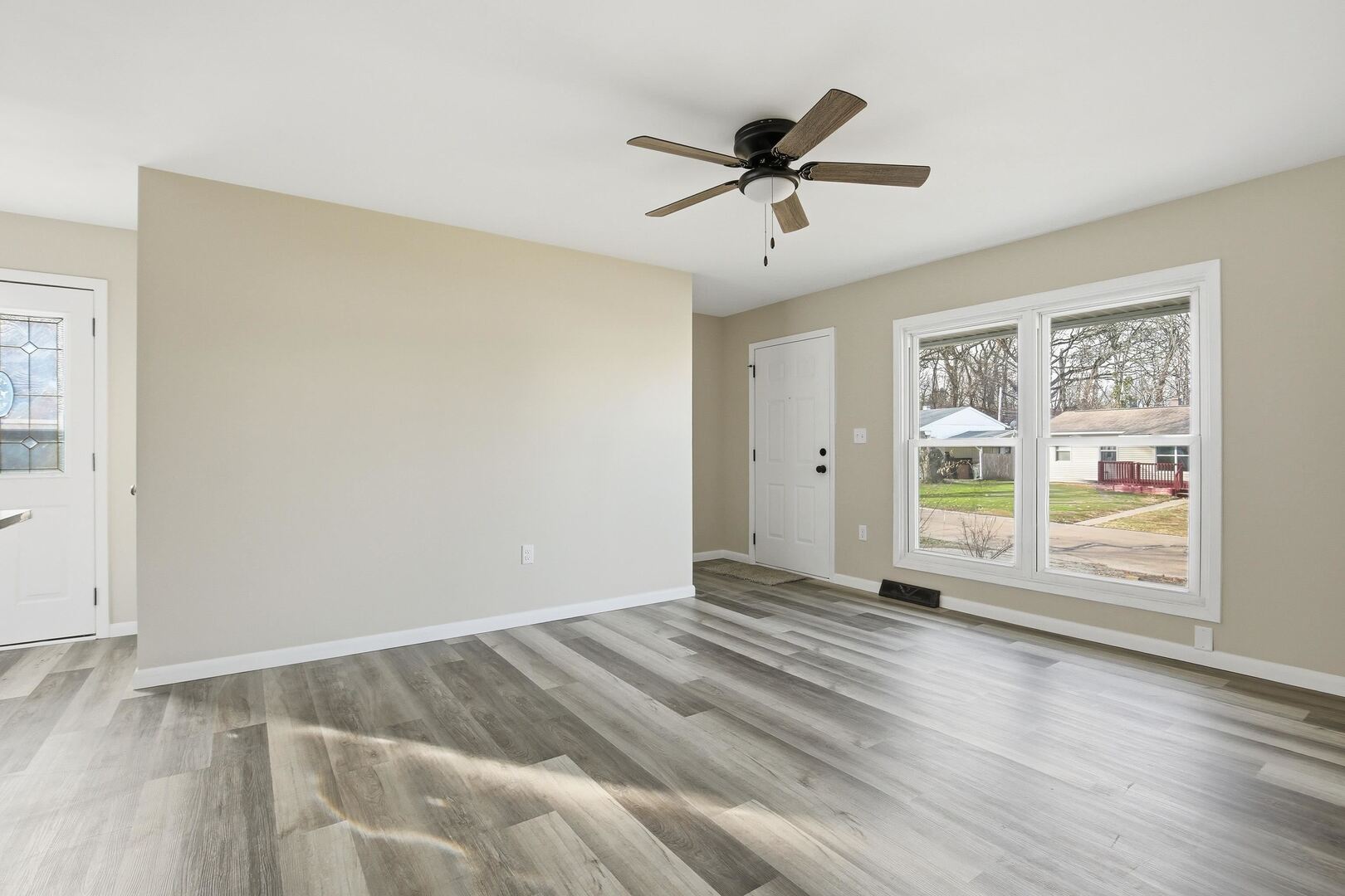 1135 6th Street West Milan, IL 61264 - Photo 3 of 36 a view of an empty room with a window and wooden floor
