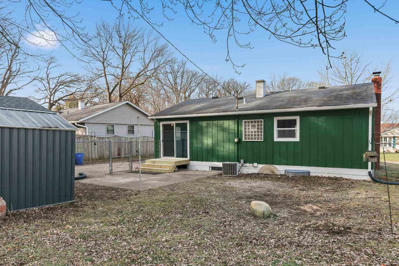 1135 6th Street West Milan, IL 61264 - Photo 34 of 36 a front view of a house with a garden and trees