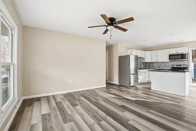 a view of kitchen with granite countertop cabinets and refrigerator