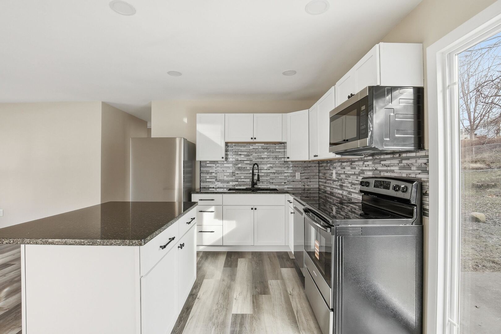 1135 6th Street West Milan, IL 61264 - Photo 9 of 36 a kitchen with a sink stove and microwave
