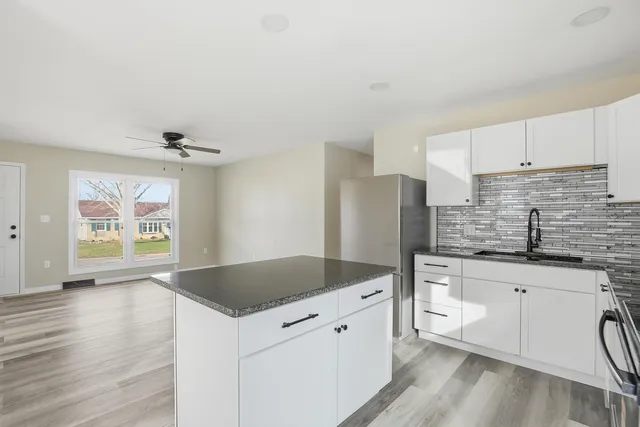 a kitchen with granite countertop a sink stove and refrigerator