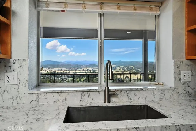 a kitchen with a stove a sink a dining table and chairs with wooden floor