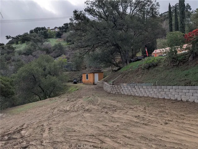 a view of a dry yard with wooden fence