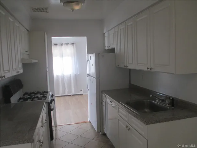 a kitchen with a refrigerator and a stove top oven