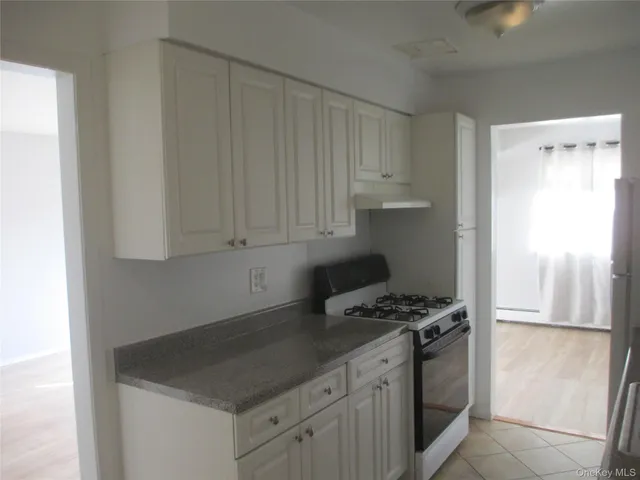 a kitchen with granite countertop a sink cabinets and stainless steel appliances