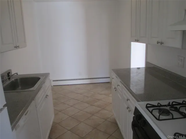 a kitchen with a sink and white cabinets