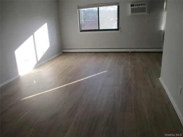a view of a room with wooden floor and window