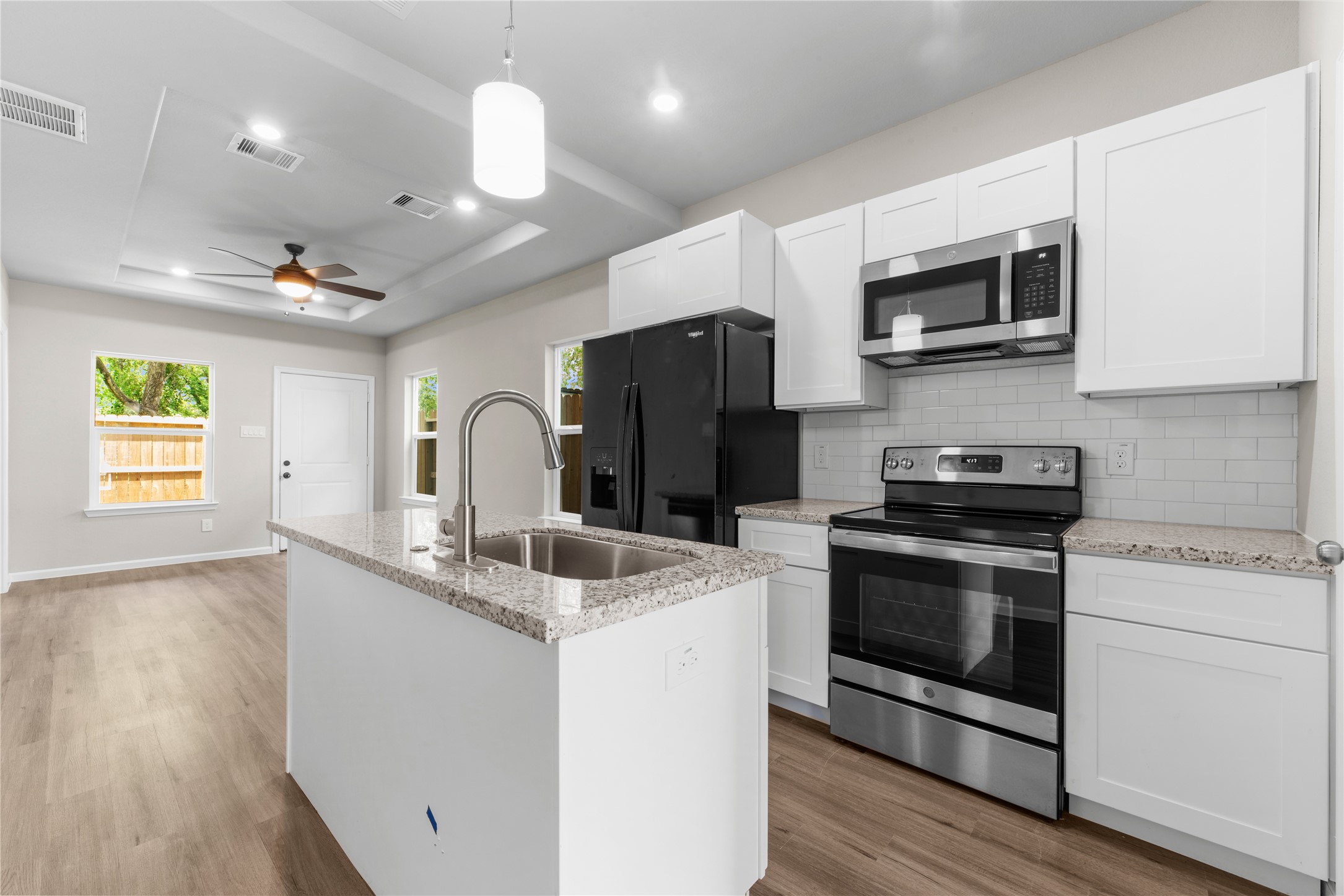 8161 Tate Street, Unit B Houston, TX 77028 - Photo 3 of 14 a kitchen with stainless steel appliances granite countertop a sink a stove a microwave and wooden floors
