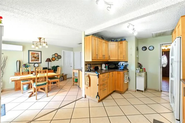 a view of a dining room with furniture one side kitchen view and a chandelier