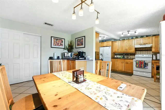 a living room with stainless steel appliances kitchen island granite countertop furniture and a flat screen tv
