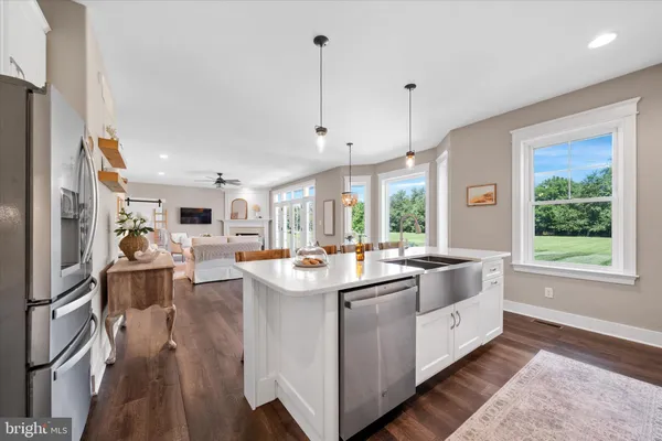 a kitchen with stainless steel appliances a dining table chairs and white cabinets