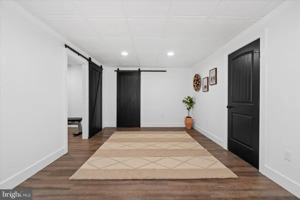 a view of a kitchen with dining space wooden floor electric appliances and windows