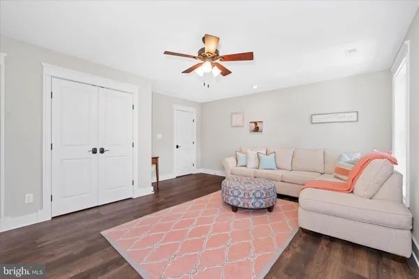 a view of a hallway view with wooden floor and a living room