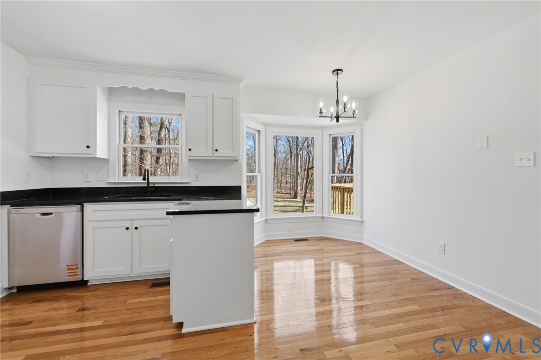 3264 Sherwood Ridge Way Powhatan, VA 23139 - Photo 16 of 40 a kitchen with granite countertop white cabinets and window
