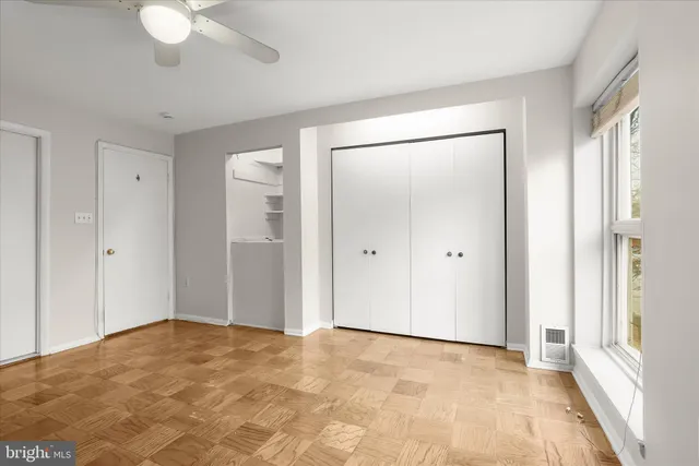 a view of an empty room with a chandelier fan