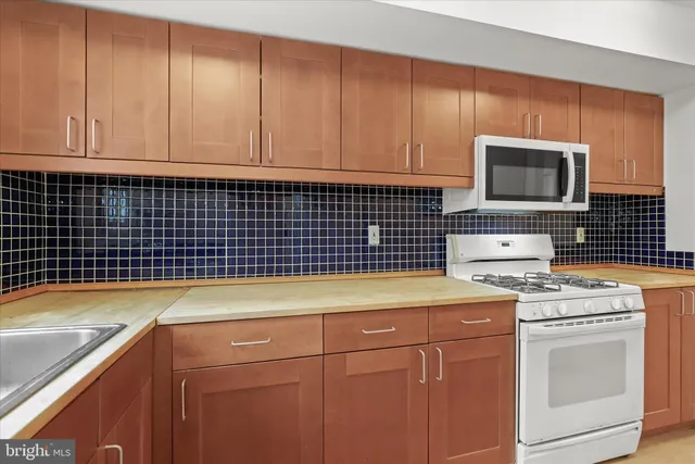 a kitchen with a sink dishwasher stove and cabinets