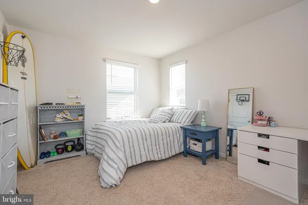 a bedroom with a bed a dresser and a window