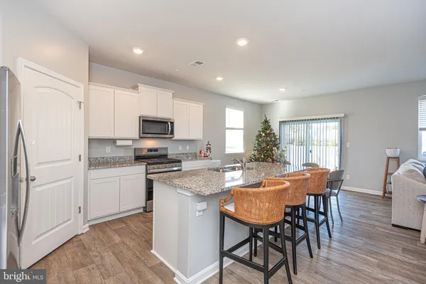 a kitchen with a table chairs refrigerator and microwave