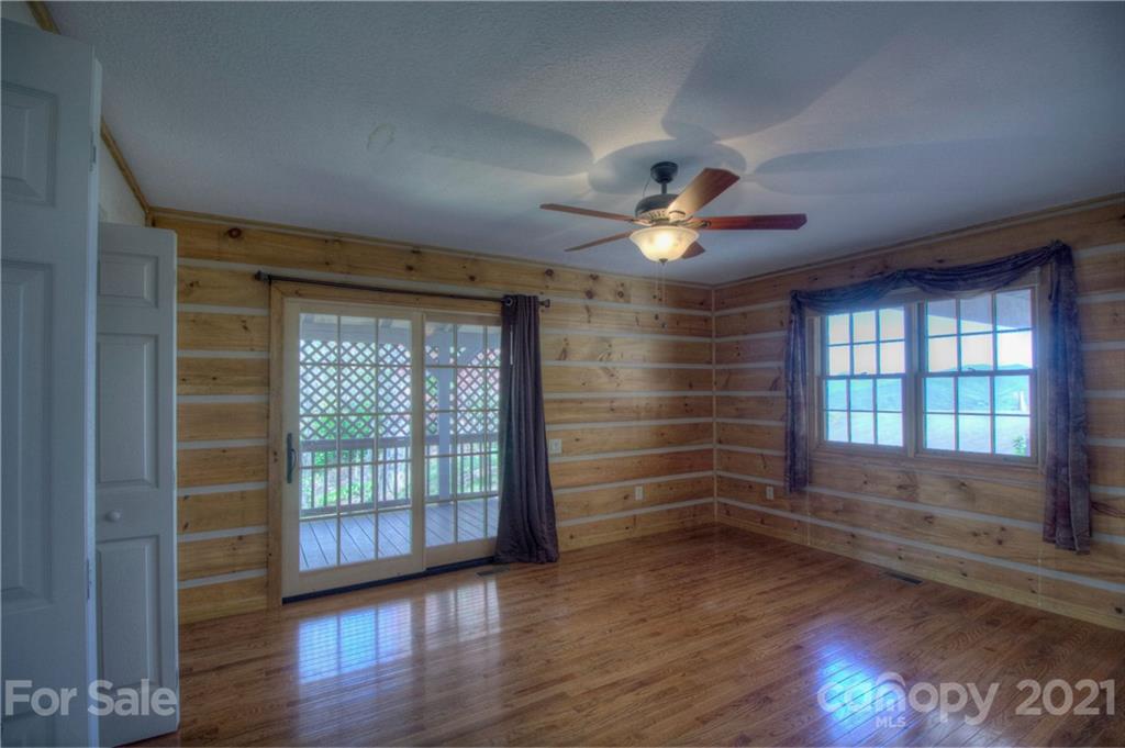 265 Smokey Ridge Loop Waynesville, NC 28786 - Photo 22 of 34 a view of wooden floor and a chandelier fan in a room