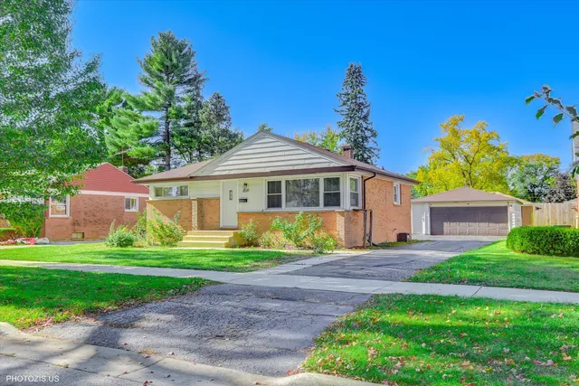 a front view of a house with a yard and trees