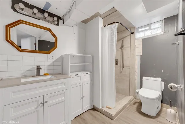 a bathroom with a toilet a sink and mirror