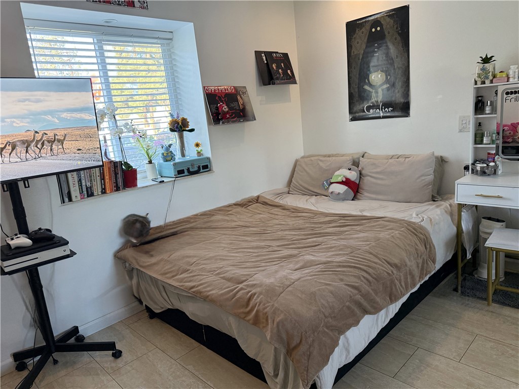 7672 Amazon Drive, Unit 1 Huntington Beach, CA 92647 - Photo 12 of 24 a bedroom with a bed and a table in it