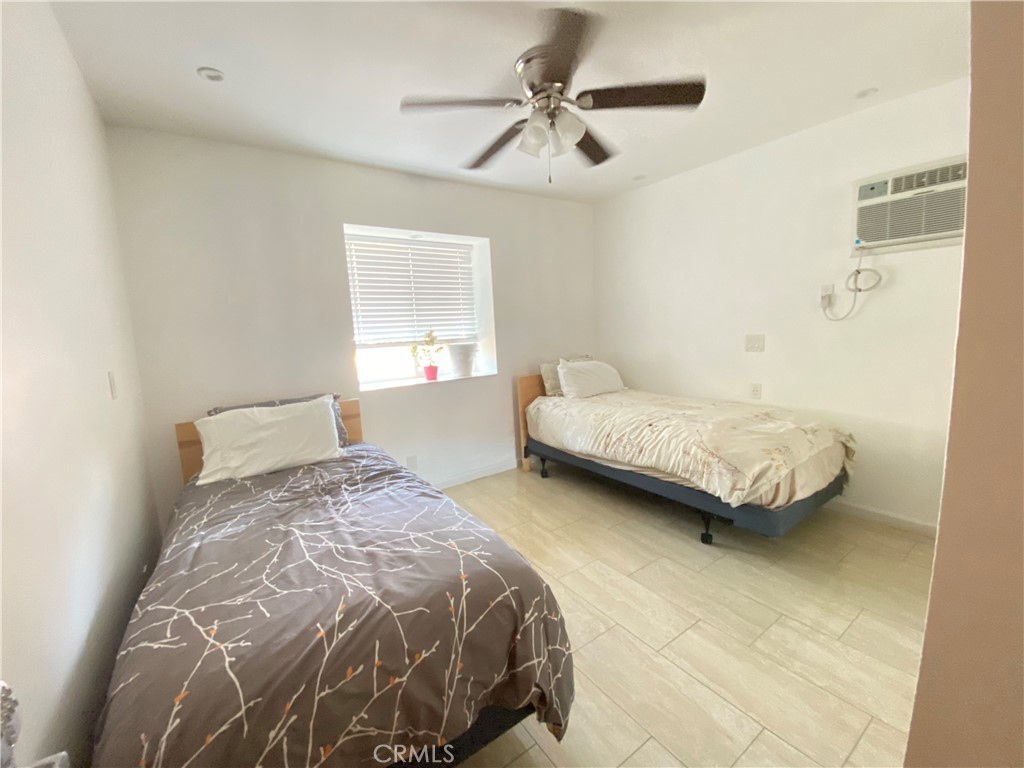 7672 Amazon Drive, Unit 1 Huntington Beach, CA 92647 - Photo 14 of 24 a bedroom with a bed and a chandelier