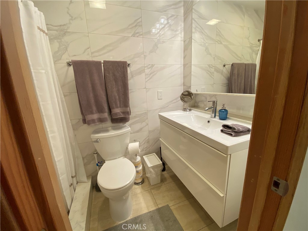 7672 Amazon Drive, Unit 1 Huntington Beach, CA 92647 - Photo 17 of 24 a bathroom with a sink toilet and mirror