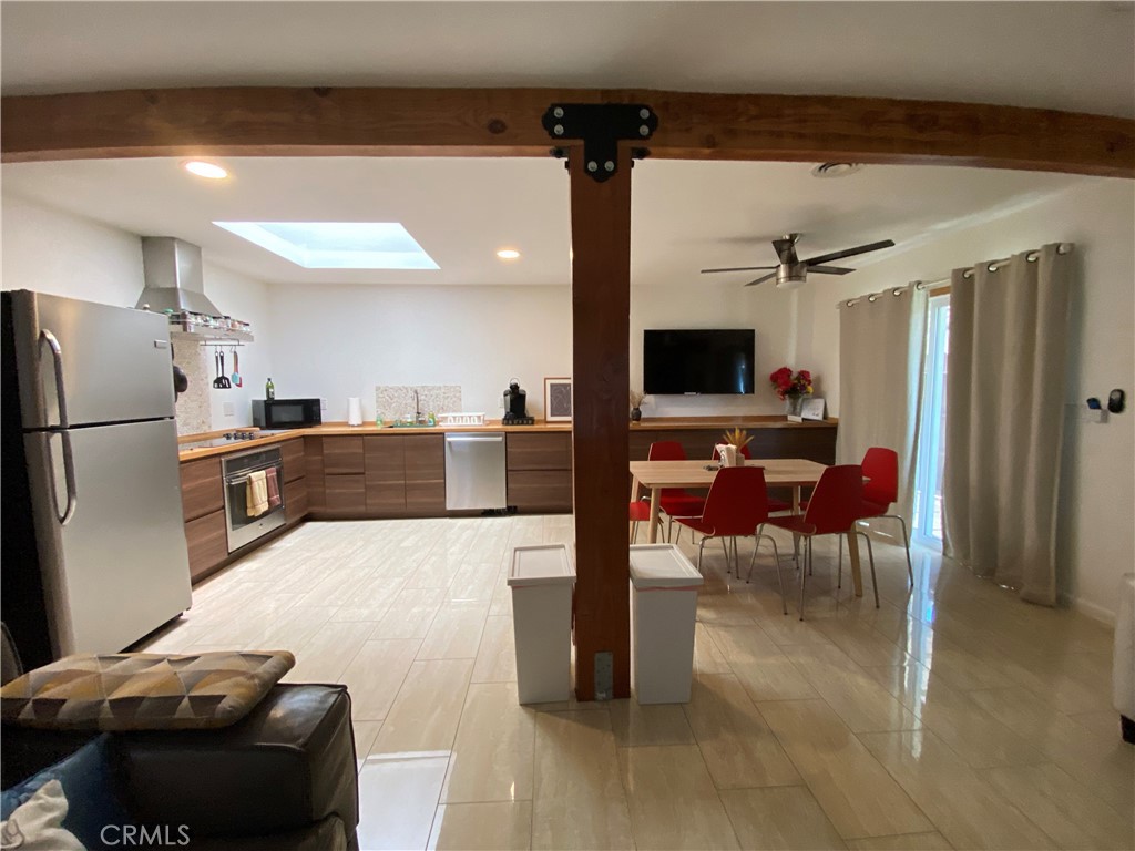 7672 Amazon Drive, Unit 1 Huntington Beach, CA 92647 - Photo 7 of 24 a kitchen with stainless steel appliances wooden floor and a refrigerator