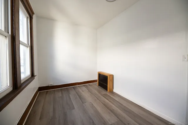 a view of empty room with wooden floor