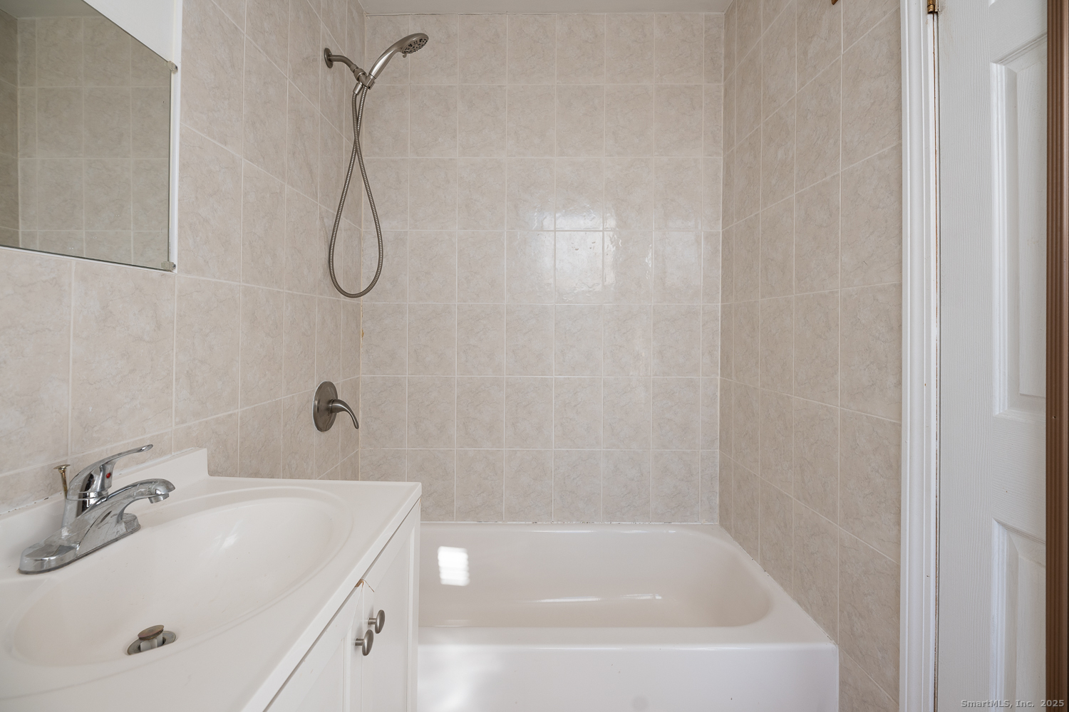 239 Forbes Avenue New Haven, CT 06512 - Photo 9 of 13 a bathroom with a white bath tub sitting next to a white sink and vanity