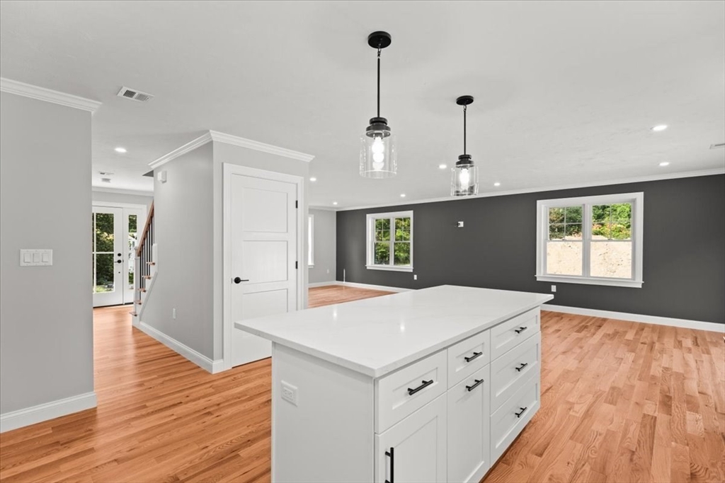 15 Elm Place Hanson, MA 02341 - Photo 17 of 27 a room with kitchen island a sink wooden floor and a refrigerator