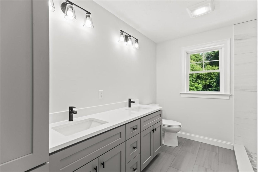 15 Elm Place Hanson, MA 02341 - Photo 22 of 27 a bathroom with a double vanity sink a toilet and a mirror