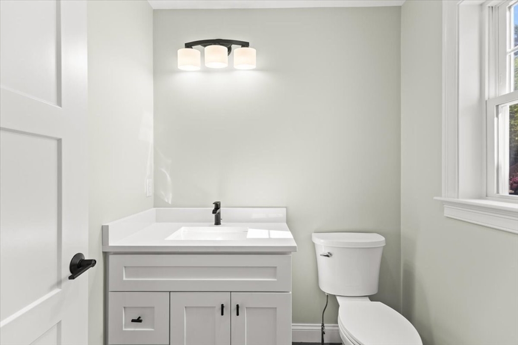 15 Elm Place Hanson, MA 02341 - Photo 7 of 27 a bathroom with a sink a toilet and a mirror