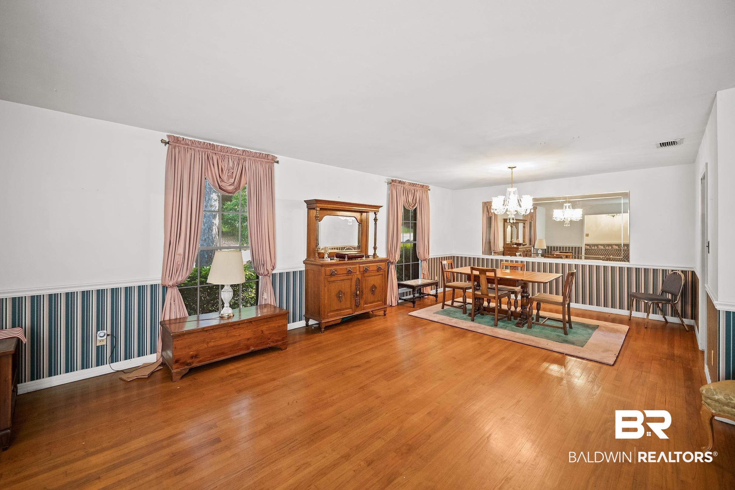 135 Pineridge Road Daphne, AL 36526 - Photo 3 of 19 Hardwood flooring spans this room, featuring multiple windows with natural light and a chandelier over the dining area