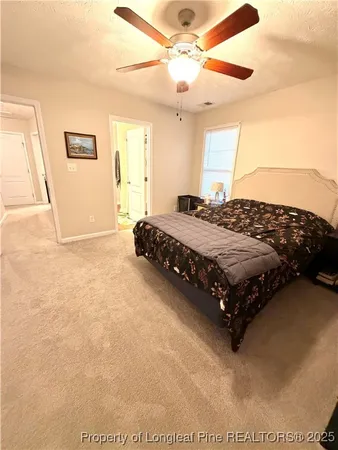 a bedroom with a bed painting on wall and a large window