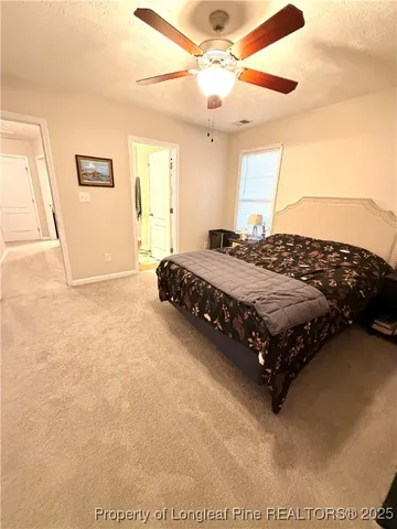 a bedroom with a bed painting on wall and a large window