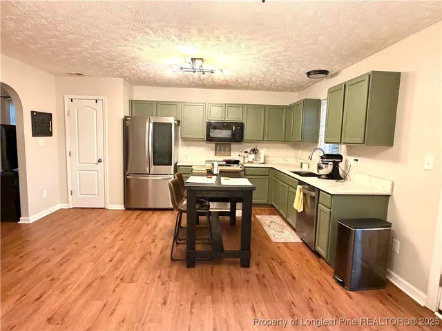 a kitchen with a sink appliances and cabinets