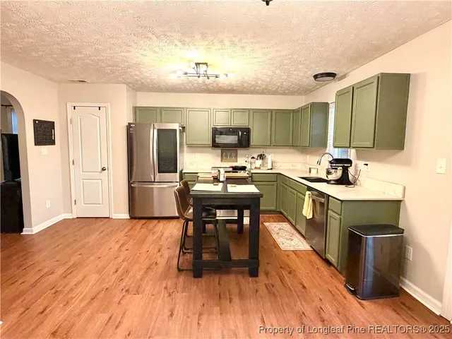 a kitchen with a sink appliances and cabinets