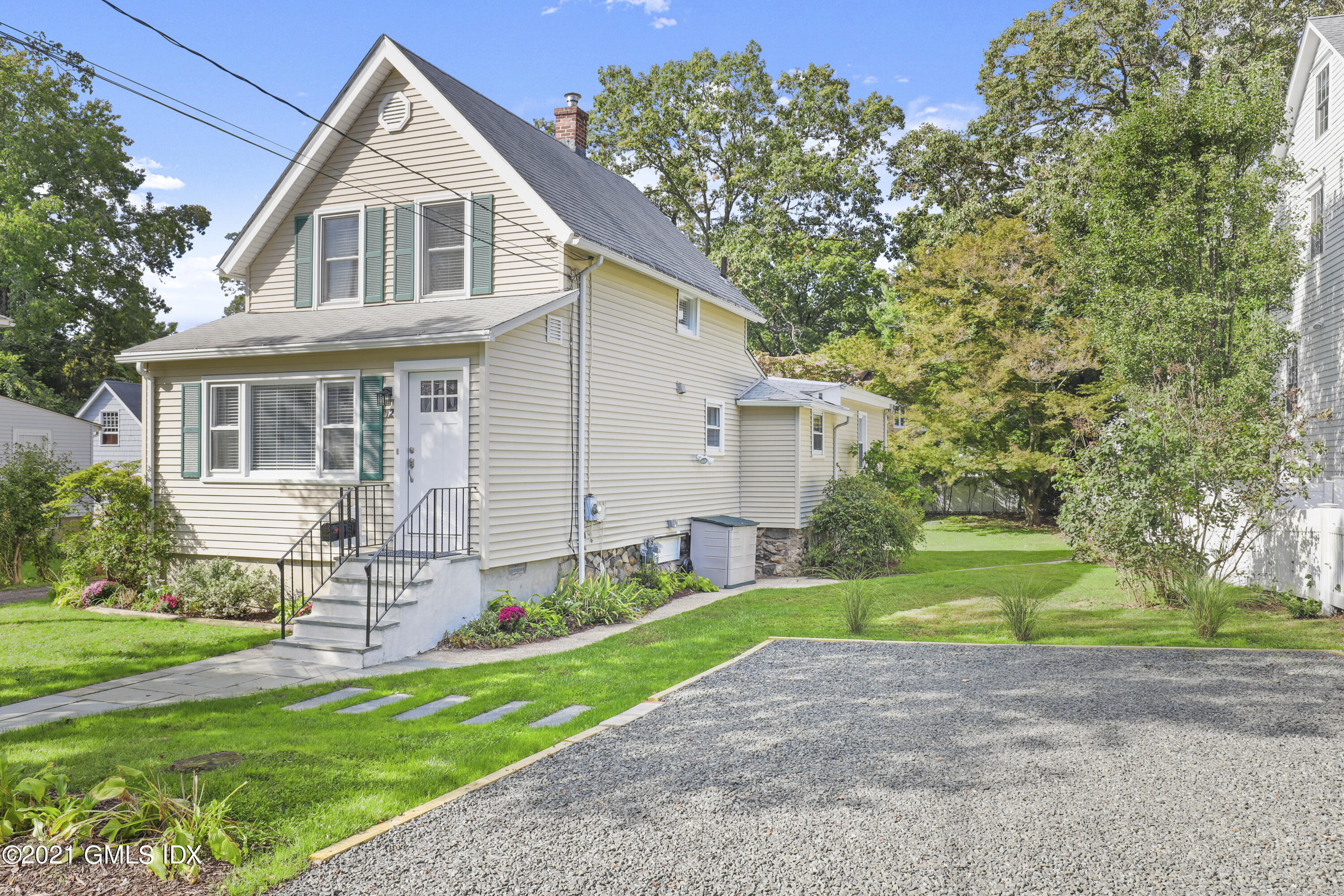 a front view of a house with a yard and trees