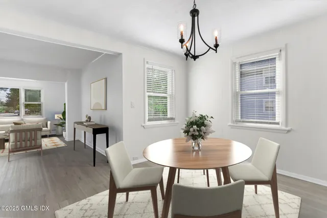 a dining room with furniture a chandelier and wooden floor