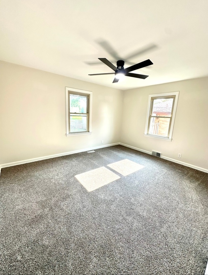 906 West Walnut Street Kankakee, IL 60901 - Photo 7 of 14 an empty room with windows and fan